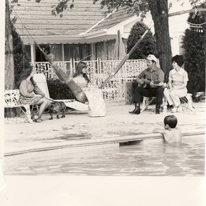 Conway Twitty sits around the pool at his home in Moore, Oklahoma, with his wife Mickey, son Jimmy, daughters Joni and Kathy and dog Tojo.