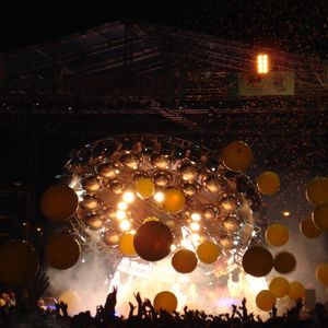 The Flaming Lips perform on-stage at Dfest in Tulsa, OK in July of 2007 under a huge "UFO" stage-prop from the documentary film, "UFOs at the Zoo: The Flaming Lips Live in Oklahoma City."
