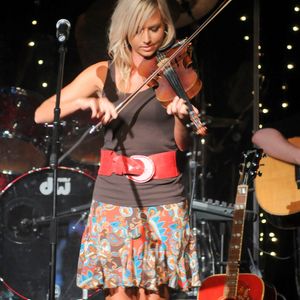 A fiddle player performs onstage with a band at the Oklahoma Opry.