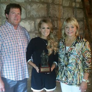 Oklahoma Governor Mary Fallin and her husband present Carrie Underwood with a small replica of the "Pioneer Woman" statue that stands in Ponca City in July 2014.
