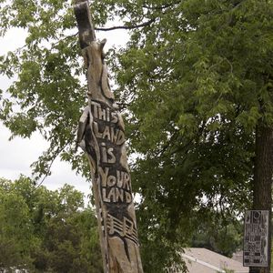 This carving stands where Woody Guthrie's childhood home, The London House, once stood.