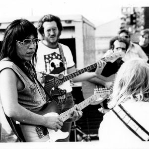 Jesse Ed Davis, left, with Gary Gilmore and JJ Cale in background, performing with Leon Russell at the Tulsa Fairgrounds Racetrack on June 18, 1972.