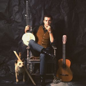 Mason Williams posing with musical instruments and a stuffed dog for the cover of Theme Poems, which was released in 1964 on VeeJay Records