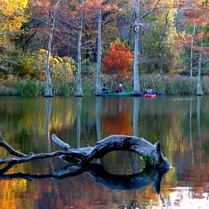 Fishermen chat in their canoes as fall beauty surrounds them at Beavers Bend State Park.