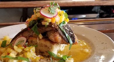 Indulge in specials like Hawaiian Kanpachi served over a hatch chili grit cake with fresh pineapple salsa and mango puree.