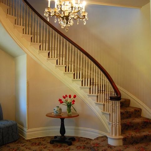The exquisite staircase of the Pecan Valley Inn Bed & Breakfast curls upward around a crystal chandelier.
