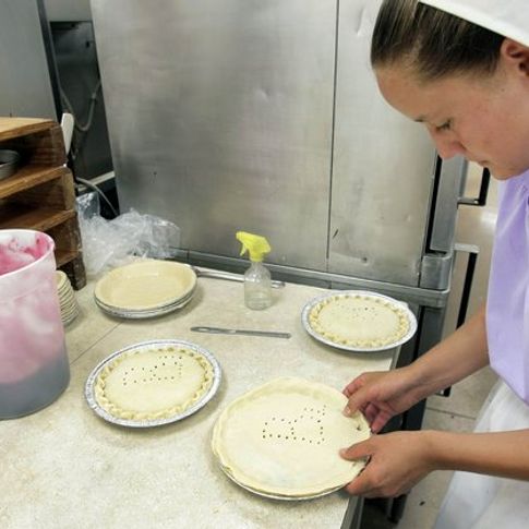 Amish woman preparing fresh baked goods at Nettie Ann's Bakery, part of the Amish Cheese House in Chouteau.