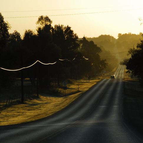 A rural stretch of Route 66 glows at sunset.