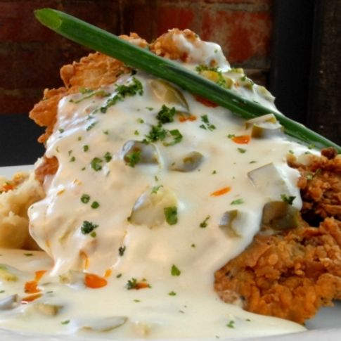 The traditional chicken-fried steak takes on a contemporary edge at Cheever&#039;s Cafe in Oklahoma City where it is served over red-skinned garlic mashed potatoes with jalapeno gravy.