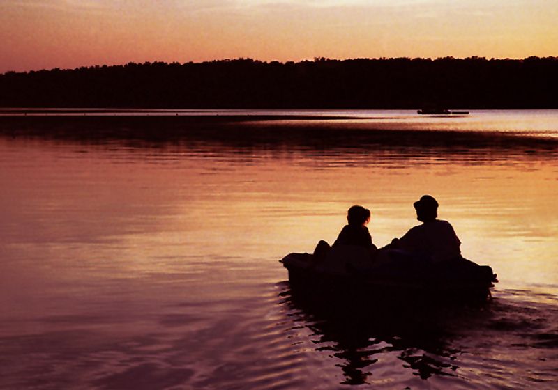 A grandfather takes his granddaughter for a paddleboat ride at sunset on Lake Eufaula.