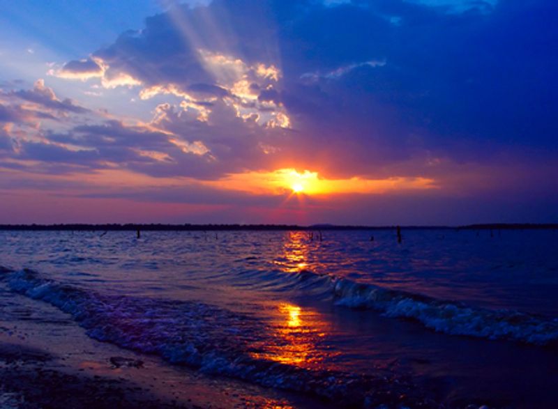 An outstanding Oklahoma sunset shines over the waves of Lake Eufaula.