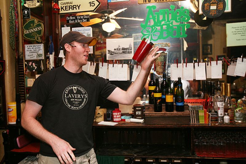 Arnie's Bar is a popular nightlife spot in Tulsa's Blue Dome District where the bartenders entertain the patrons as they mix drinks.