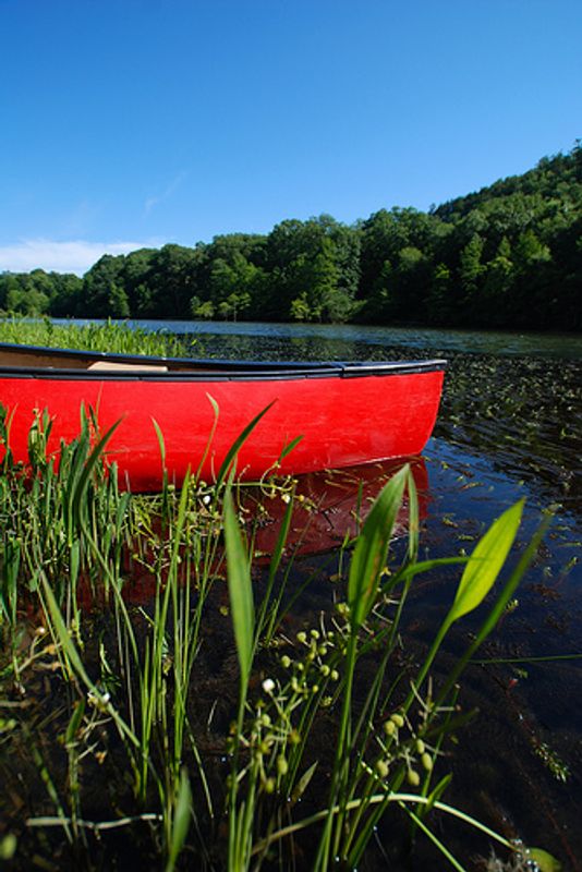 A bright canoe adds an artistic touch to this scenic Mountain Fork River waterscape. The Mountain Fork River in southeastern Oklahoma's Beavers Bend State Park is a popular floating destination.