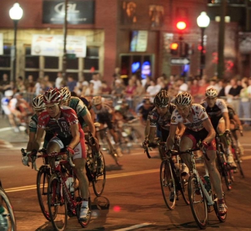 Bicyclists race toward the finish line under the glow of nighttime Tulsa during the annual Tulsa Tough Ride & Race.