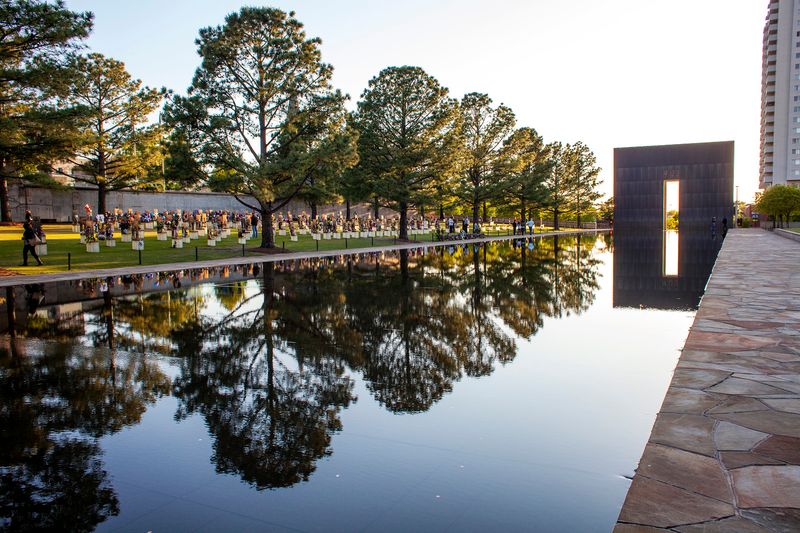 The Field of Empty Chairs at the Oklahoma City National Memorial honors each of the 168 people who were killed, and a 318-foot long reflecting pool fills the corridor between the monumental bronze-clad Gates of Time.
