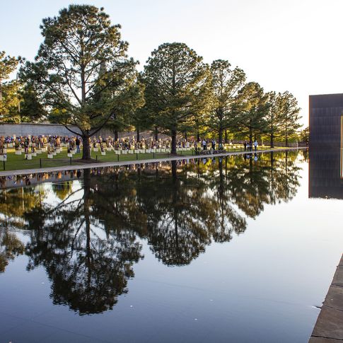 The Field of Empty Chairs at the Oklahoma City National Memorial honors each of the 168 people who were killed, and a 318-foot long reflecting pool fills the corridor between the monumental bronze-clad Gates of Time.