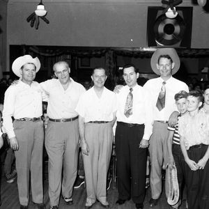 Johnnie Lee Wills (in the cowboy hat on the left) and Leon McAuliffe (in the cowboy hat on the right) posing with an unidentified group