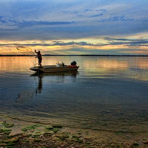 A fisherman casts for bait along the shores of Lake Eufaula.  A well-known tournament lake, Lake Eufaula draws anglers from across the United States to test their skills at catching largemouth bass, smallmouth bass, Kentucky bass, crappie, catfish, sandbass and other species.