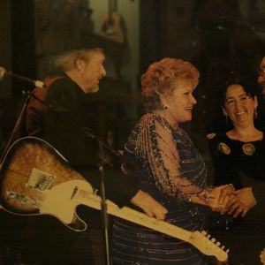 Patti Page, with Merle Haggard behind her, shakes hands after a performance at the Oklahoma Music Hall of Fame in Muskogee.