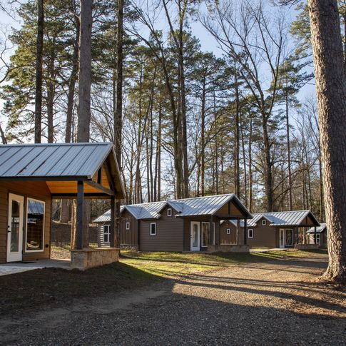 Pack light and unwind in a stylish tiny cabin with riverfront views of the Lower Mountain Fork at Beavers Bend State Park.