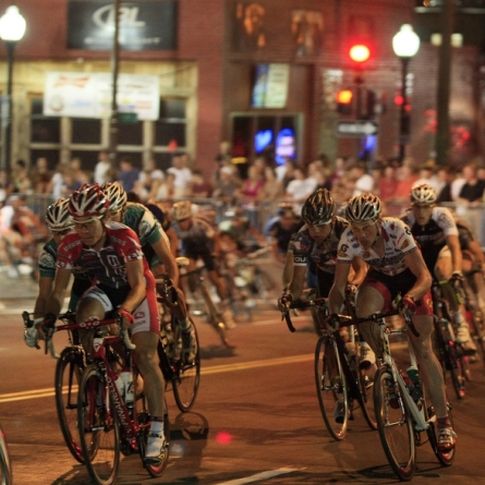 Bicyclists race toward the finish line under the glow of nighttime Tulsa during the annual Tulsa Tough Ride & Race.