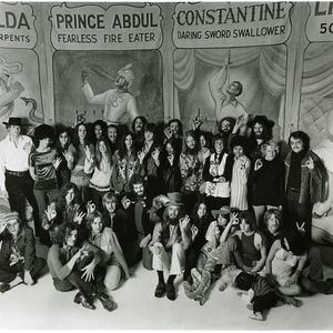 Leon Russell, seated in the center wearing a top hat, poses with the performers of the Mad Dogs and Englishmen tour.  