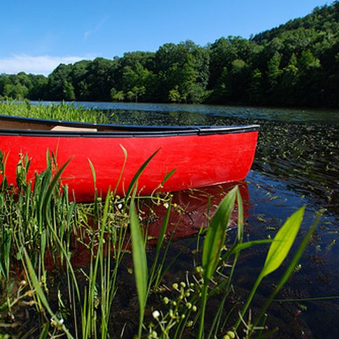 A bright canoe adds an artistic touch to this scenic Mountain Fork River waterscape.  The Mountain Fork River in southeastern Oklahoma's Beavers Bend State Park is a popular floating destination.