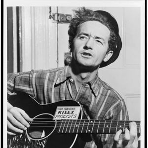 Woody Guthrie was known for political lyrics and the note on his guitar, which reads, "This machine kills fascists."